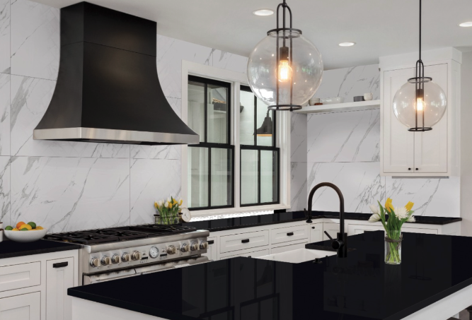 A kitchen with black and white marble counter tops.